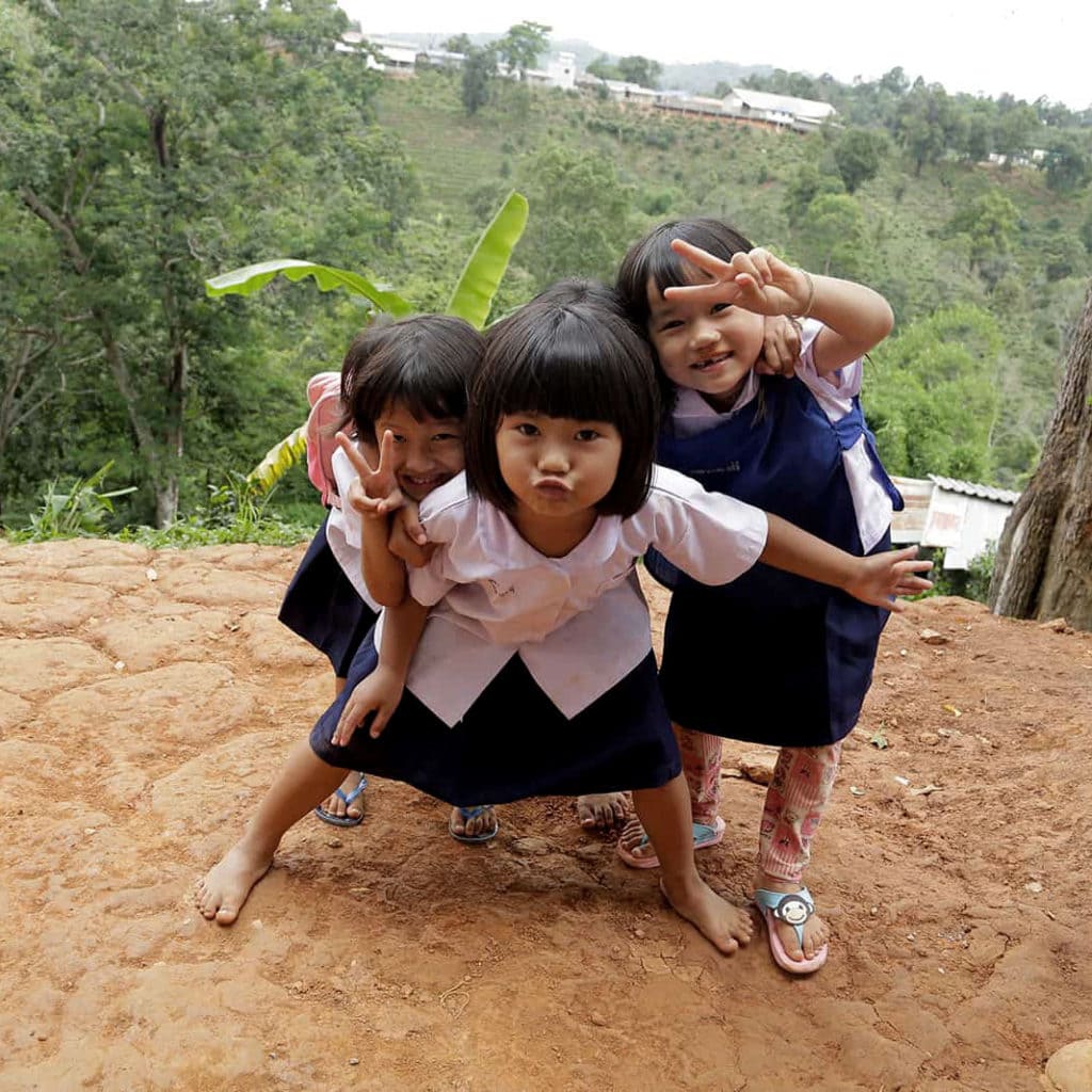 alt="girls-in-thailand-showing-the-peace-sign-compassion-Deutschland"