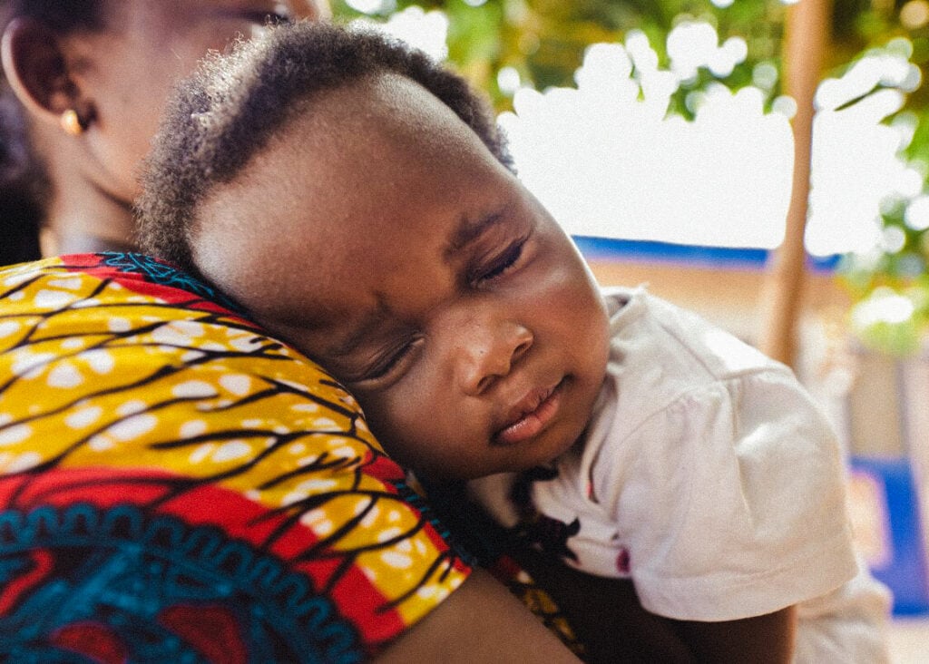 alt="Weltgesundheitstag_2022_Weltgesundheitstag2022_Augenoperation_Grauer_Star_kleines_Mädchen_lächelt_schläft_auf_Mamas_Schulter_Ghana_Afrika_Compassion_Blog_Compassion_Deutschland"