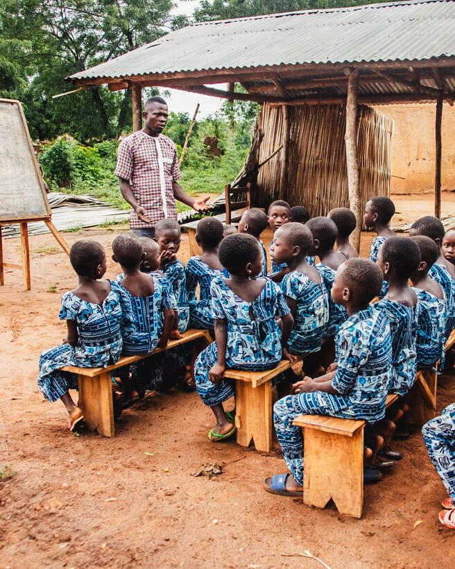 alt="Tag_gegen_Kinderarbeit_Raphael_mit_Kindern_in_der_Schule_in_Togo_gemeinsam_gegen_Kinderarbeit_Compassion_Deutschland"