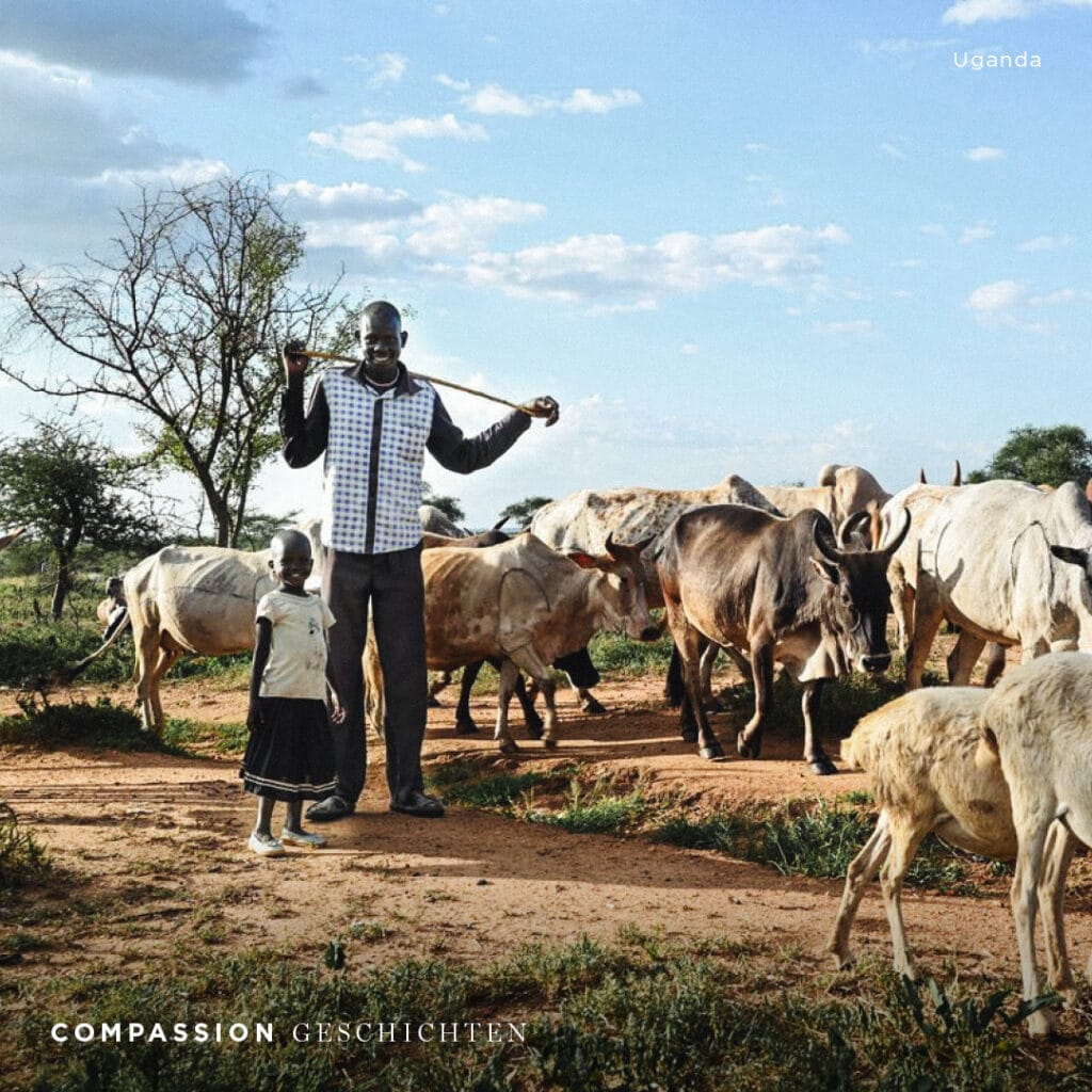 alt="Eli mit Kinder und Frau auf Feld mit Kühen Geschichte Uganda Lebensmittelknappheit Überleben Diebstahl Compassion Deutschland"