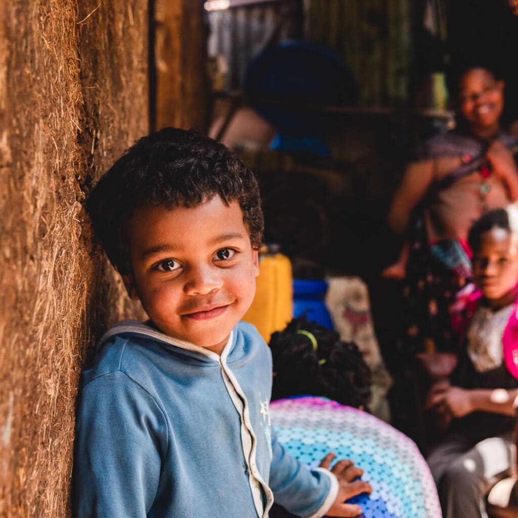 alt="Wie wirkt sich die Lebensmittelkrise auf Kinder aus? Compassion Deutschland Lebensmittelhilfe | Sohn von Abijot in Hütte mit Kindern"