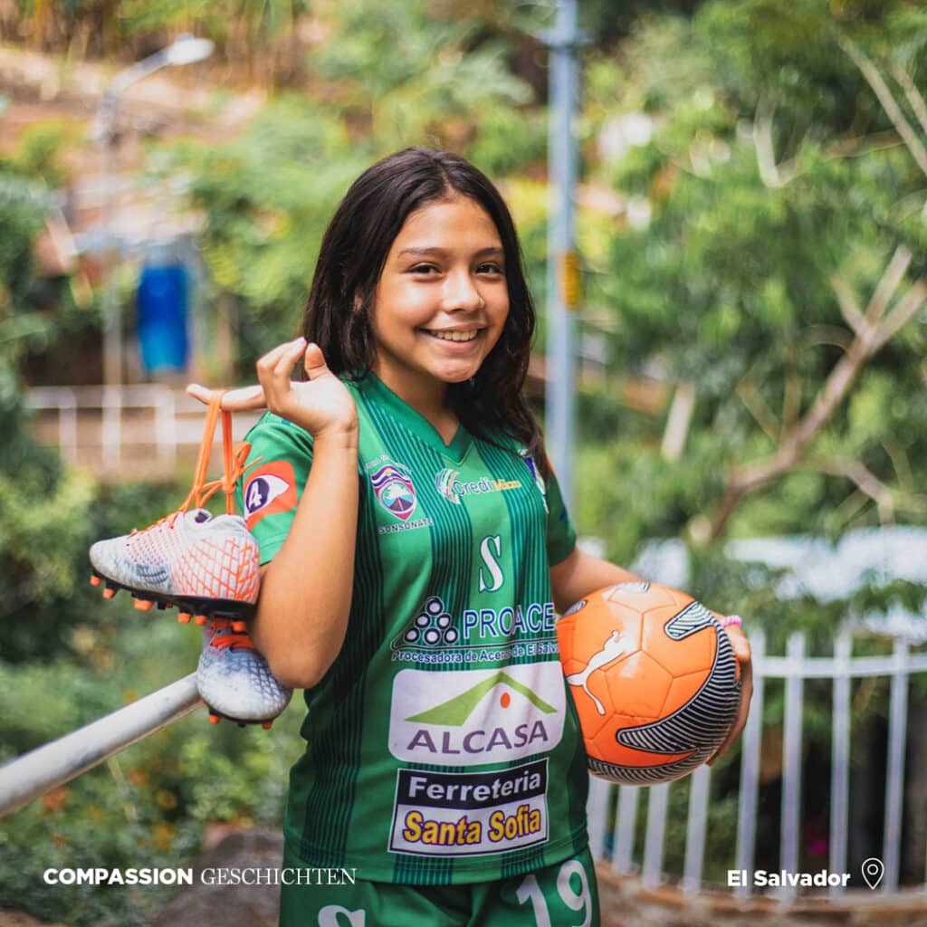 alt="Karlas Geschichte, Fußball spielen ist ihr Hobby, Karla mit ihrem Fußballschuhen, El Salvador"