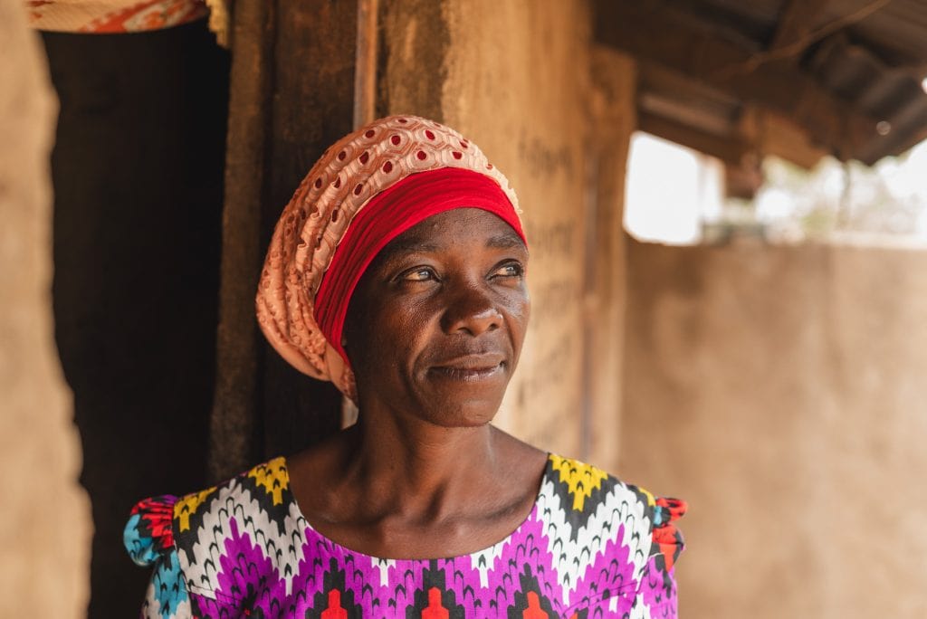 alt="Die Früchte meiner Arbeit, Frau schaut aus einer Hütte in Afrika, Compassion Deutschland, Muskathlon Home"