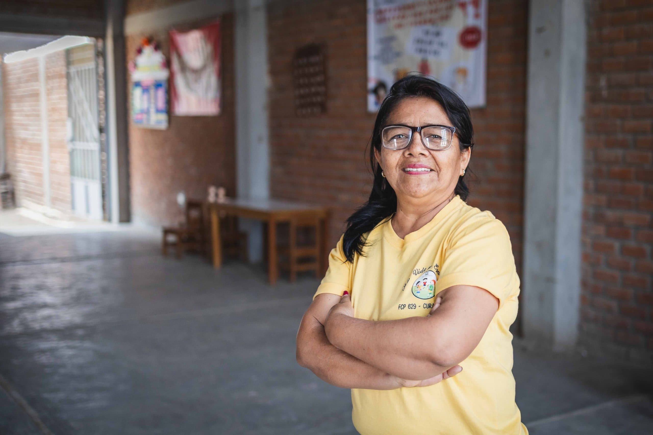 alt="Eine Gruppe von Frauen steht lächelnd vor einem neu errichteten Haus in Peru – Zeichen für Gemeinschaft, Wiederaufbau und Hoffnung nach einer Flutkatastrophe."