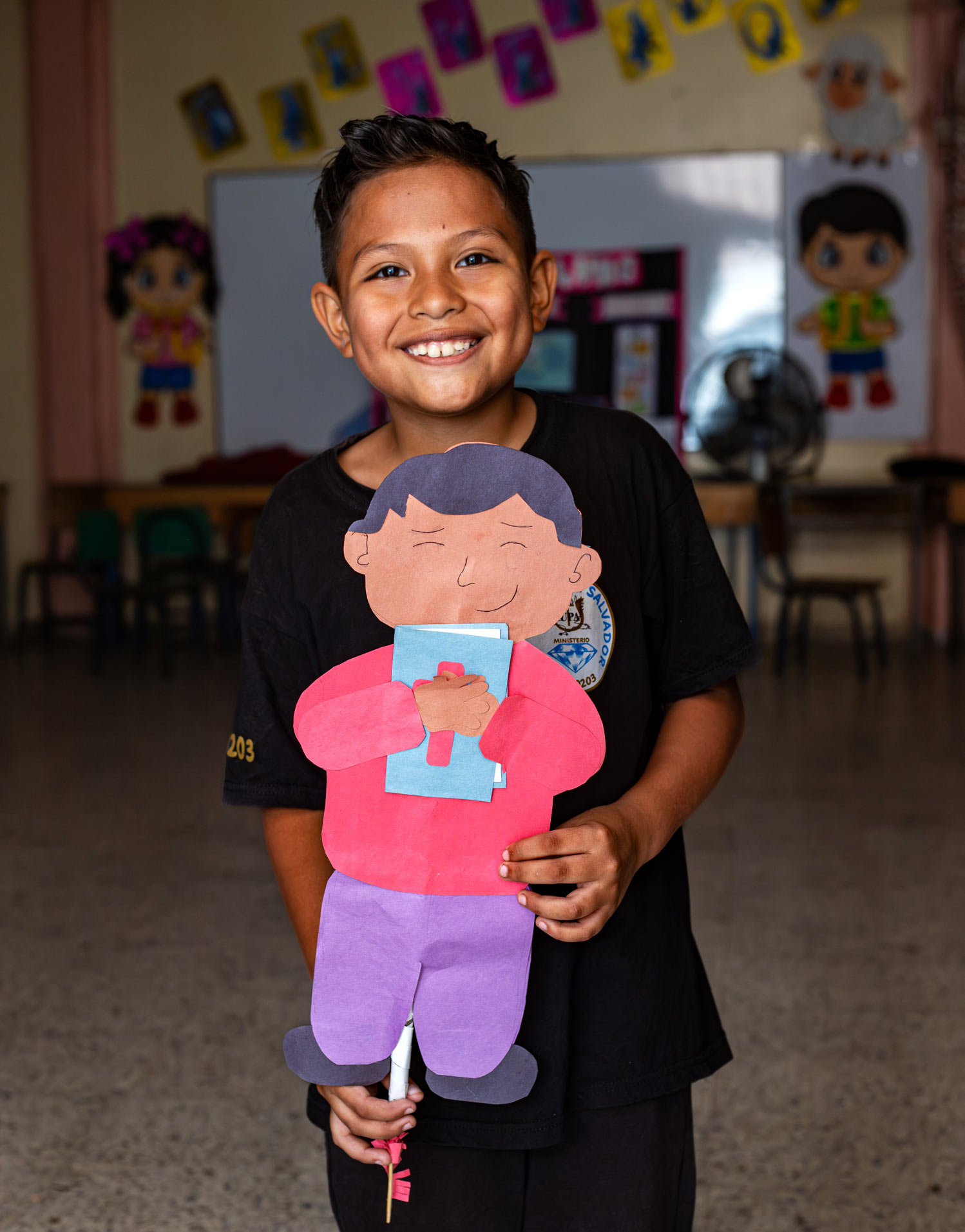 alt="Junge mit gebasteltem Jungen in den Händen, im Compassion Kinderzentrum, Kinderschutzmarsch in Honduras, Compassion Deutschland"