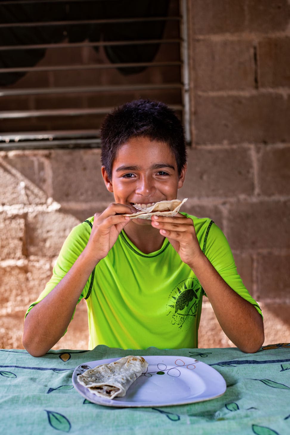 alt="3 Wege gegen Unterernährung, Junge beim Essen, Compassion Deutschland"