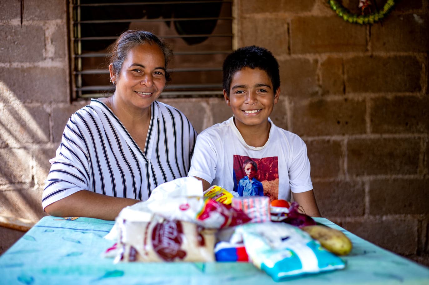 alt="3 Wege gegen Unterernährung, Mutter mit Sohn mit Lebensmitteln, Compassion Deutschland"