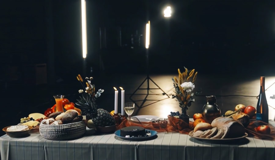Ein gedeckter Tisch mit Essen, Getränken und Kerzen, Tellerrand - Musikvideo mit Daniel Harter, Marco Michalzik und Compassion Deutschland
