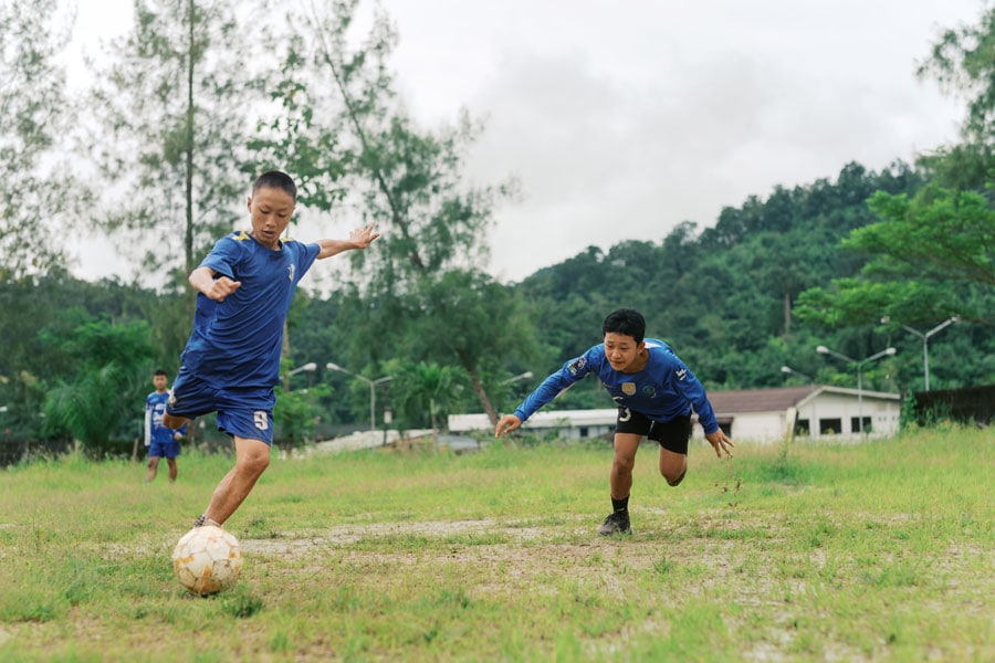 Zwei Jungs spielen Fußball auf einer Wiese