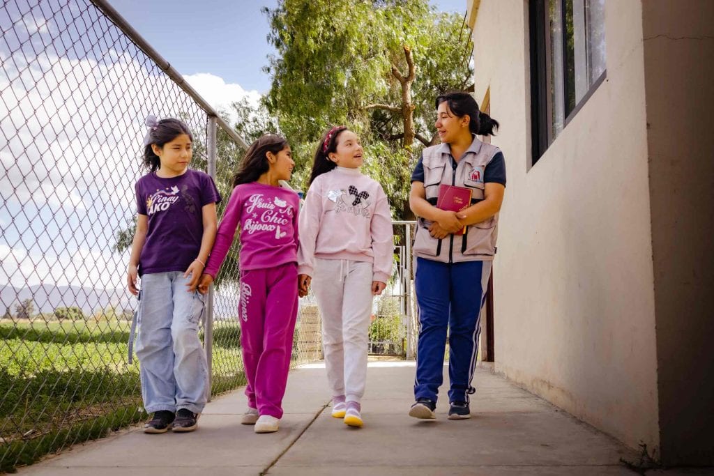 Mädchen laufen neben einer Mitarbeiterin im Kinderzentrum, Wie wir Kinder schützen wollen, Compassion Deutschland
